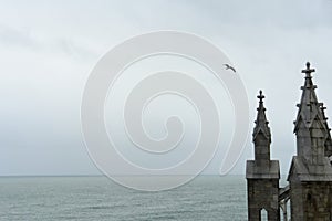 Pinnacles of a church, the sea and a seagull