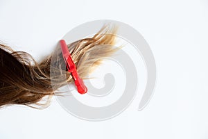 Pinned up female hair lies on a white background, a clip on the hair