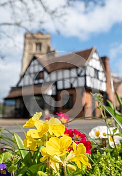 Pinner Parish Church in the High Street, Pinner Middlesex, UK with historic half timbered building in front. Colourful primula flo photo