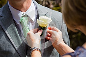 Pinning Boutineer on Groom photo