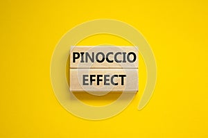 Pinoccio effect symbol. Concept words Pinoccio effect on wooden blocks on a beautiful yellow background. Business and Pinoccio