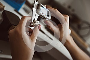 Pinpoint accuracy. Close up photo of female jeweler`s hands measuring ring with a tool in workshop.