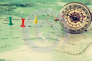 pins attached to map, showing location or travel destination and old compass.