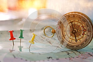 pins attached to map, showing location or travel destination and old compass.