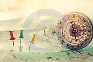 pins attached to map, showing location or travel destination and old compass.