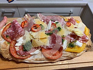 fresh pinsa with salami, tomato, pesto, mozzarella and parmesan cheese, crispy pinsa, different kind of pizza, pinsa romana photo