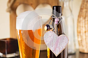 Pint of frothy beer with a heart photo