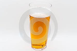 Pint of cold lager beer in a glass and isolated on a white background