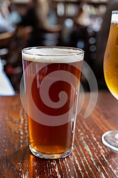 Pint glass of british golden ale or ipa beer served in old vintage English pub