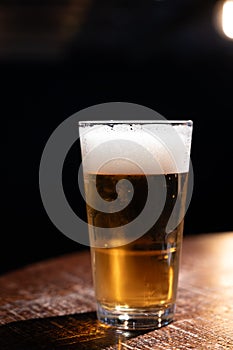 Pint glass of cold fresh british ale and lager beer served in old vintage English pub