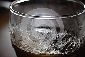 Pint glass filled with cold drink up close, condensation visible on glass