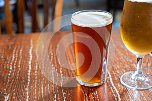 Pint glasses of british ale and lager beer served in old vintage English pub