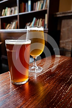 Pint glasses of british ale and lager beer served in old vintage English pub