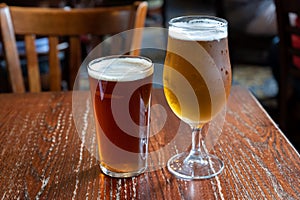 Pint glasses of british ale and lager beer served in old vintage English pub