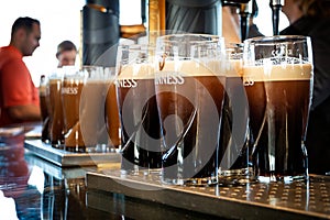 Pints of Guinness are being served in a pub in Dublin, Ireland - February 15, 2014