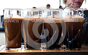 Pints of Guinness are being served in a pub in Dublin, Ireland - February 15, 2014