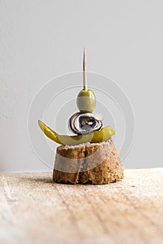 Pintxos Pintxo, Olive, Anchovy, Green Guindilla on a Rustic Board, food from the Basque Country photo