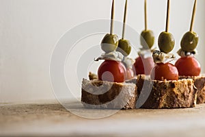 Pintxos Pintxo set, olive, anchovy, cherry tomato and bread on a Rustic Board, food from the Basque Country