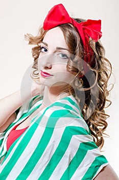 Pinup girl beautiful young woman with red lips and a bow on her head looking at the camera closeup portrait picture