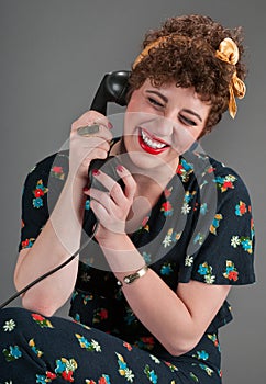 Pinup Girl in Flowered Outfit Laughs While on the Telephone