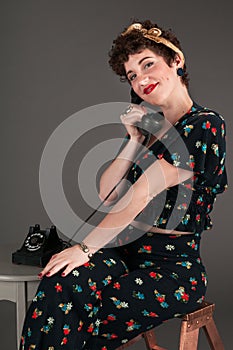 Pinup Girl in Flowered Outfit Smiles Gently on the Phone