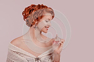 Pinup girl holding bottle of perfume and smelling aroma