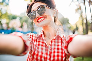 Pinup girl selfie shot outdoors, fifties fashion