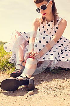 Pinup Girl with white petticoat dress waiting on the wayside