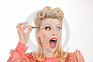 Pinup makeup. Funny woman gets eyebrow correction procedure. Young woman tweezing her eyebrows in beauty saloon. Young