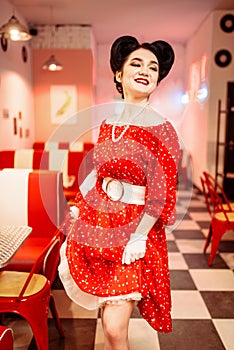 Pinup woman in retro cafe with checkerboard floor