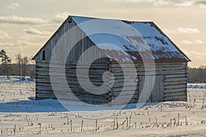 Pioneer log cabin barn in Eastern ontario in winter