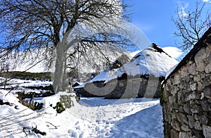 Piornedo, Ancares, Galicia, Spain. Ancient snowy palloza houses made with stone and straw. Village covered with snow.