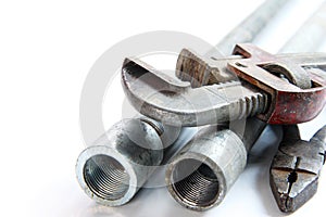 pipe alligator wrench ,pliers and steel pipes on white background