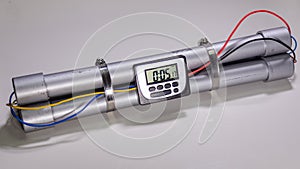 Pipe bomb with an clock timer to trigger detonation on white background