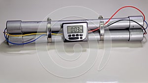 Pipe bomb with an clock timer to trigger detonation on white background