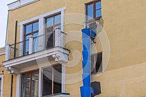 Pipe for debris, waste tube. Blue telescope rubble chute. Plastic garbage chute fixed on facade. Repair in apartment, office of