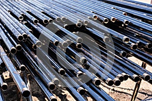 Pipe for Drilling rigs for oil and gas on background. Drilling of oil and gas wells.