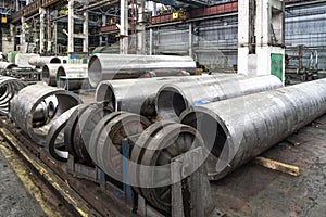 Pipe factory production line with steel tubular pipes on floor, metalwork heavy industry