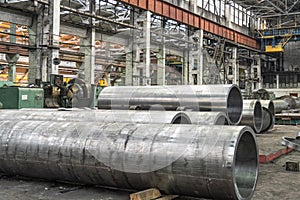 Pipe factory production line with steel tubular pipes on floor, metalwork heavy industry