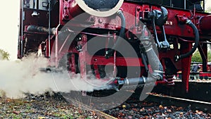 Pipe of old historic German locomotive releases thick clouds of steam