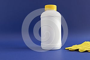 Pipe Plumber Drain Granules in White Plastic Bottle With Yellow Cap, Rubber Glove On Blue