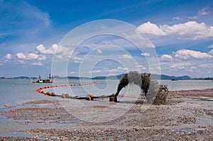Pipe pushing sand onto the beach
