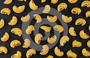 Pipe rigate pasta pattern on black background, top view, flat lay texture