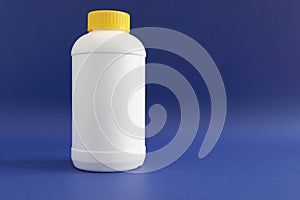 Pipe Unclogging Granules In Yellow Cap, White Plastic Bottle On Blue Purple Background