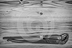 Pipe wrench on a wooden table.