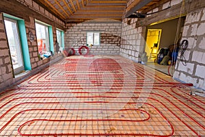 Pipefitter installing system of heating or underfloor heating installation. Water floor heating system interior.