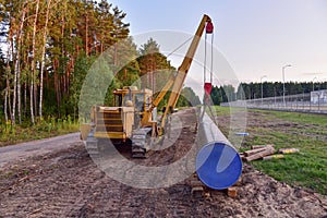 Pipelayer with side boom for Install of  natural gas and crude oil pipes in ground. Construction of the gas pipes. Pipeline