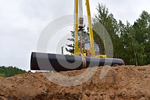 Pipelayer with side boom during Natural gas pipeline construction work. Installation in the ground of industrial gas and oil pipes