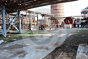 Pipeline overpass with iron pipes for pumping liquid against the background of a large brick smoke pipe at an oil refinery, petroc