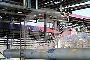 Pipeline overpass with iron rusty pipes for pumping liquid, condensate with outlets and drains in oil refinery, petrochemical, che